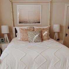 a white bed sitting in a bedroom next to two lamps on either side of it