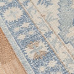 a blue and white rug on top of a wooden floor next to a wood floor