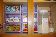 an organized pantry with cereal, milk and other food in bins on the shelves