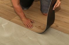 a man is working on a wooden floor with a guitar in the middle of it