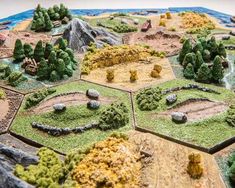 a close up of a game board with trees and rocks