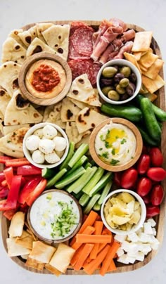 a platter filled with different types of appetizers and dips on it