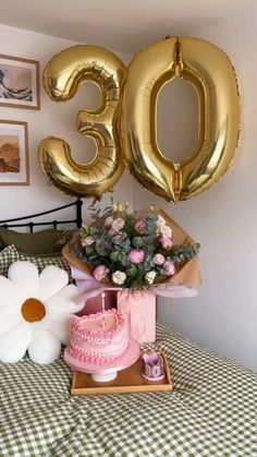 a birthday cake and balloons on a bed with the number 50 balloon in the background