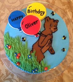 a birthday cake decorated with an image of a bear holding balloons