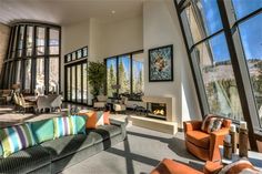 a living room filled with lots of windows next to a fire place in a building