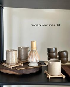 a black table topped with vases and other items on top of a wooden tray