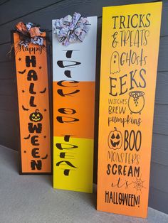 three halloween door hangers with words and decorations on them, each decorated in different colors