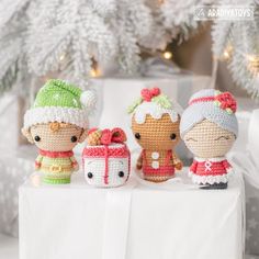 three crocheted dolls sitting next to each other on top of a white table