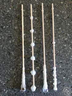 three toothbrushes lined up next to each other on a counter top with white beads