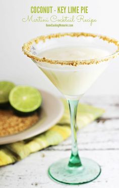 coconut key lime pie martini cocktail in a coupe glass on a white table with limes