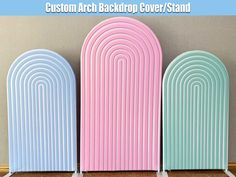 three pastel colored arch back drop covers stand next to each other in front of a wall