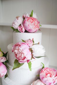 three tiered cake with pink and white flowers on top