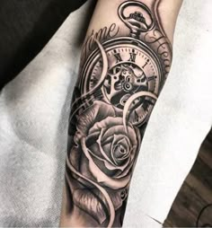 a black and white photo of a rose with a pocket watch tattoo on the arm