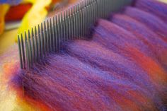 a close up of a comb with purple and orange hair