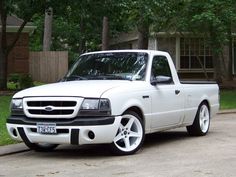 a white pickup truck parked in front of a house