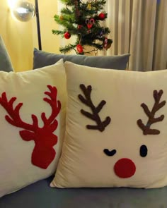 two christmas pillows with reindeer faces on them