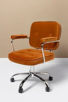 an orange office chair sitting on top of a white floor