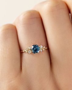 a woman's hand with a blue and white diamond ring