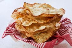 a pile of pita chips sitting on top of a red and white napkin