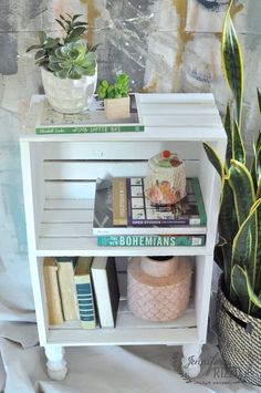 a white shelf with books and plants on it