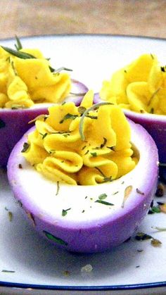 three deviled eggs on a plate with herbs