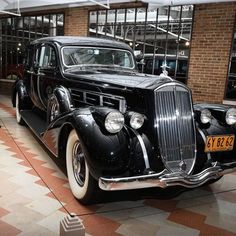 an old black car is on display in a museum