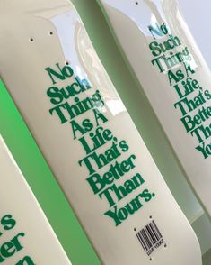 three skateboards with green lettering on them sitting next to each other in a row