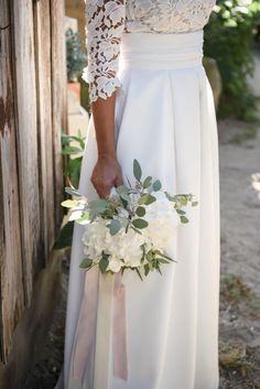 a woman in a white dress holding a bouquet