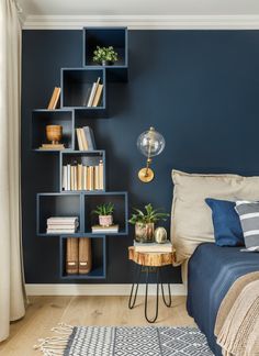 a bedroom with blue walls and bookshelves on the wall