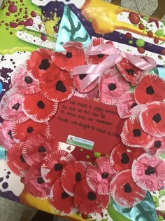 a wreath made out of paper plates with flowers on it and a poem written in the middle