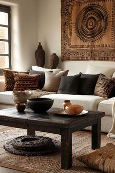 a living room filled with lots of furniture and pillows on top of a table in front of a window