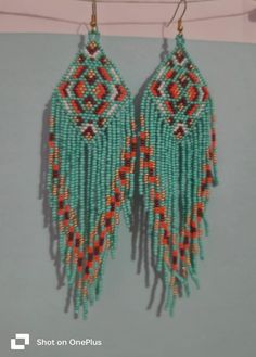 two pairs of beaded earrings hanging on a clothes line