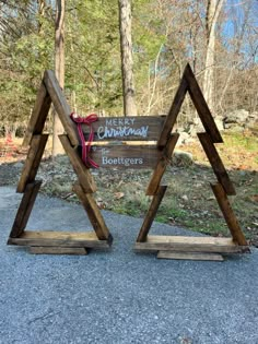 two wooden signs sitting on the side of a road