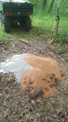 a truck parked in the woods next to a pile of dirt