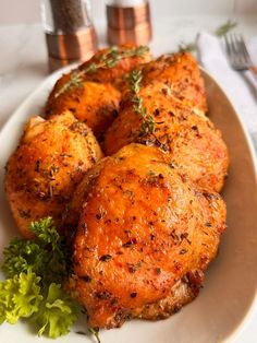 two pieces of chicken on a plate with garnish