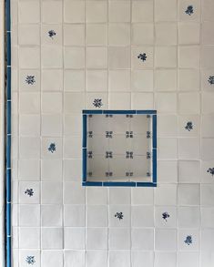 a bathroom with blue and white tiles on the wall