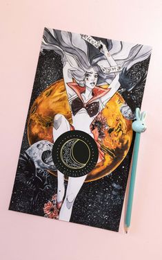 a notebook with an image of a woman on the cover and a pen next to it