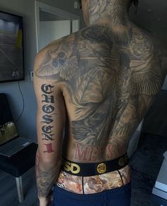 the back of a man with tattoos on his body