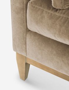 a close up view of the back end of a couch with wooden legs and armrests