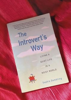 a book sitting on top of a bed covered in red sheets and blankets with the title, the introert's way living a quiet life in a noisy world