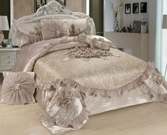 the bed is made with pink and gold comforters, pillows, and decorative decorations