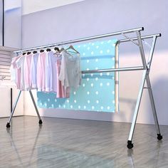 an ironing board with clothes hanging on it in front of a blue polka dot wall