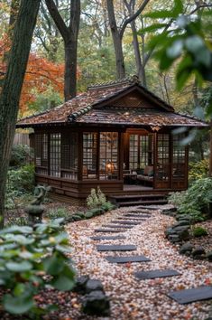 a gazebo in the middle of a forest surrounded by rocks and trees with leaves on the ground