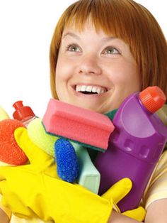 a woman holding several cleaning products in her hands