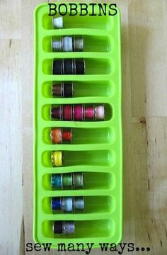 a green container filled with lots of crafting supplies on top of a wooden table