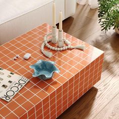 an orange tiled coffee table with candles on it