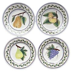 four plates with fruit painted on them