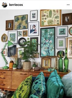 a room filled with lots of pictures on the wall and green furniture in front of it