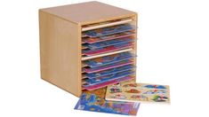 a wooden toy storage unit filled with children's books and magazines, next to its contents