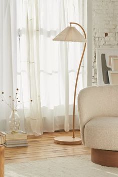 a living room with a chair, lamp and window